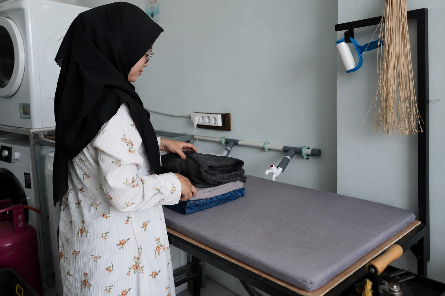 Foto seorang perempuan sedang packing pakaian setelah menyetrika
